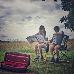 Zwei junge Musiker mitten in der Lndschaft am Wegesrand